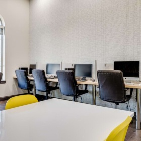 a room with computers, tables and chairs